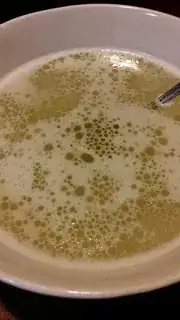 Foamy yellow broth in a bowl