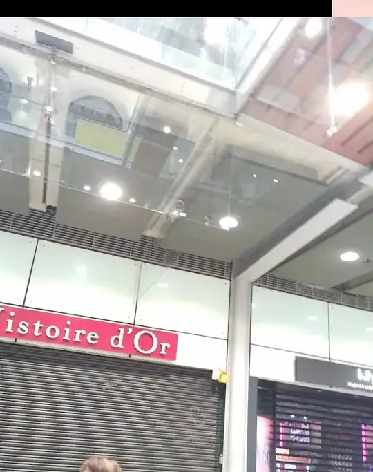 Glass panels attached to the edge of a ceiling in a train station