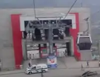 Gondolas disappearing into a station building