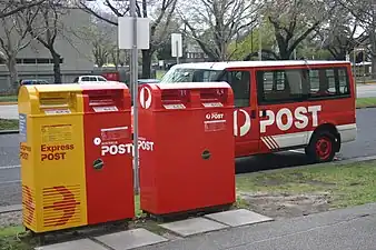 Australia, operator:  Australia_Post Australia Post normal (red) & Express Delivery (yellow) post boxes in a heavy traffic area.