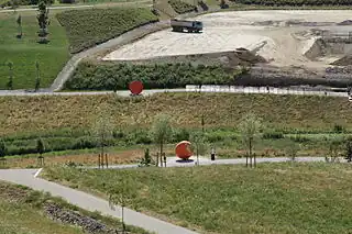 The area in the front may be mapped with leisure=park + abandoned:landuse=landfill or abandoned:landuse=quarry.