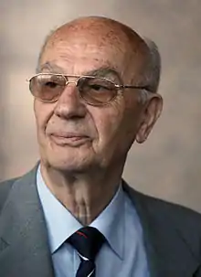 Bespectacled older man in jacket and tie