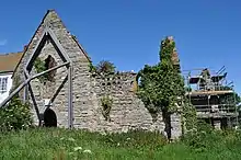 Stone wall with window of ruined building.