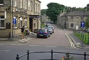 Church Street with the Newcastle Hotel to its left, connecting to Front Street (B6341), in the foreground running left to right.