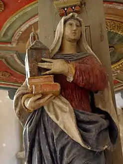 A wood carving, an allegory for "Faith",  on one of the five pillars supporting the baldachin.