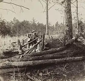 Half stereo detail of Lt George Chancellor Co E 9th Virginia Cavalry on the Wilderness Battlefield, standing at some Confederate breastworks near Palmer's field on the Orange Turnpike – George Oscar Brown, 1866