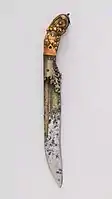 An ivory handled piha kaetta, showing liya-pata type decorative carving to the grip scales and brass inlay to the blade