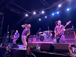 Descendents performing at the Fillmore Auditorium in 2022. 
 Left to right: Egerton, Aukerman, Stevenson (behind drum kit), and Alvarez.