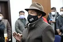 Quispe makes the sign of the cross with his hand.