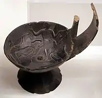 Kyathos in bucchero with man among lions, from tomb 1 of the mound of S. Paul, 670-650 BCE now National Etruscan Museum in the Villa Giulia  in Rome