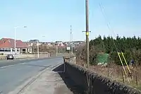 B981 towards Cowdenbeath, situated over dual carriageway (A92) just short of bridge over railway. Hill of Beath ahead