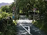 An open crossing on a narrow gauge heritage railway in Beddgelert, Gwynedd, with bilingual warning signage