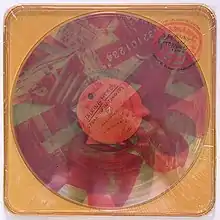 A yellow plastic case with clear vinyl albums inside that have red and blue photographs stamped onto them