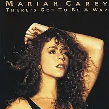 A woman with curly hair places her left arm behind her head