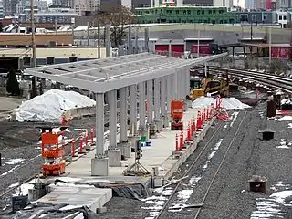 A railway station platform with the frame of a metal canopy