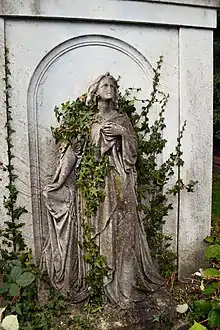 Colour photograph of an ivy-covered sculpture of a woman